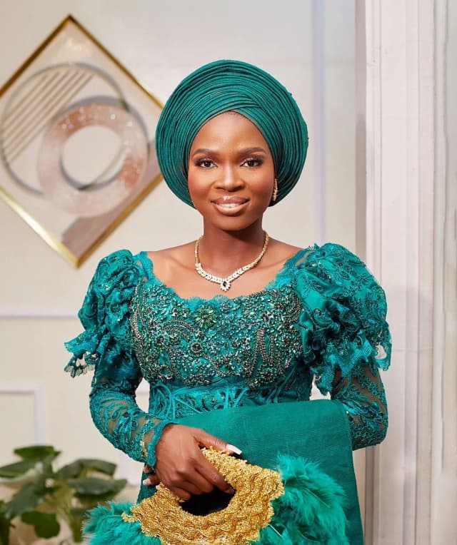 Woman in an emerald gele and lace aso-ebi
