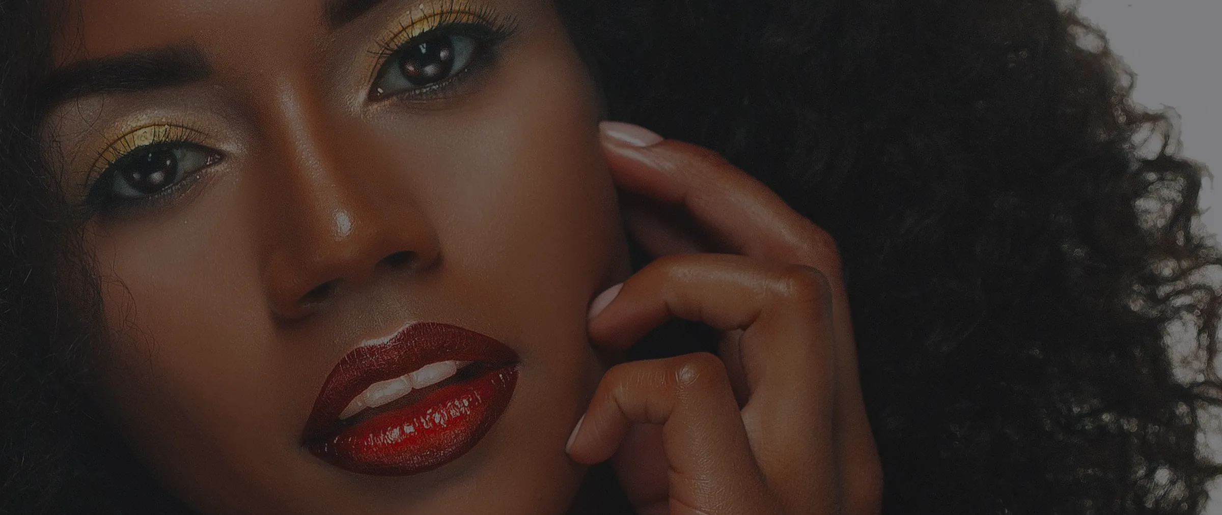 Close-up of a woman with glowing skin and glossy red lips